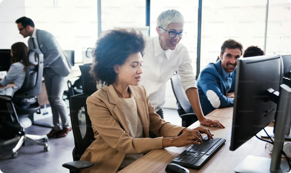 A support team working together at computers in an open-plan office